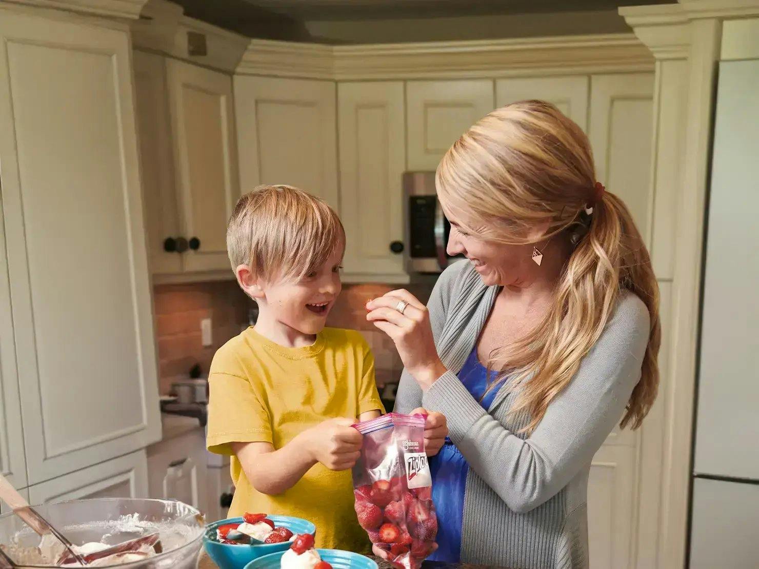 Mãe e filho comendo morangos